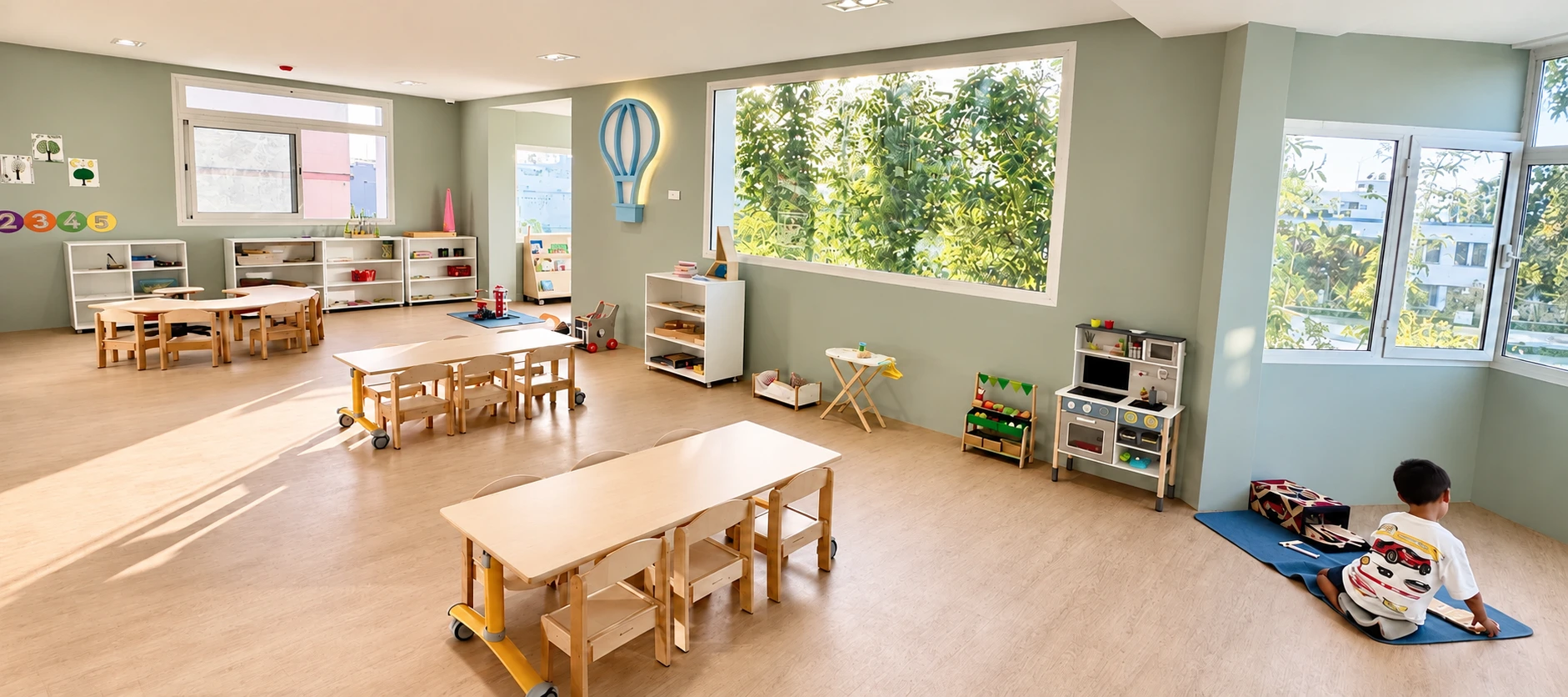 Une grande classe baignée de lumière chez Babychou, avec du mobilier à hauteur d’enfant et un enfant installé sur un tapis